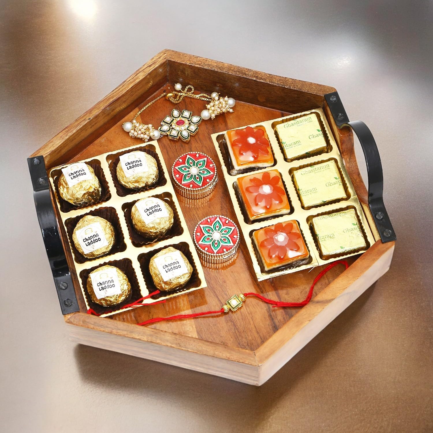 Ghasitaram Gifts Rakhi Gifts for Brothers Hexagon Tray of Assorted Bites, Laddoos, Roli Chawal Container and Bhaiya Bhabhi Rakhis
